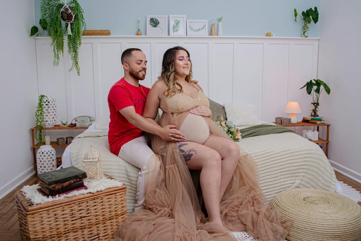 man and pregnat woman sitting on bed