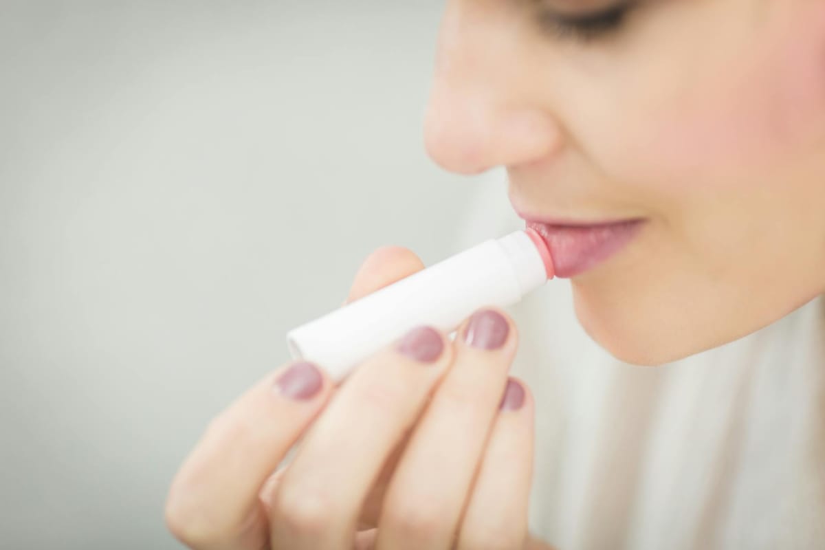 woman putting lipstick