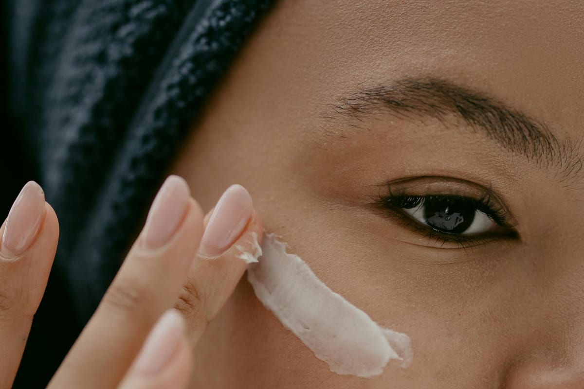 woman applying facial cream on face