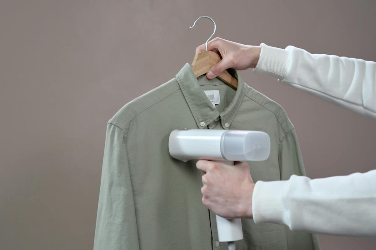 person holding gray button up shirt
