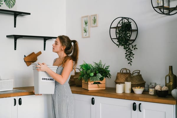 woman carrying trash bins